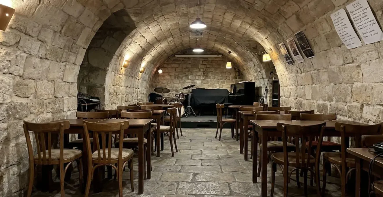 Intérieur vide d'une cave voûtée parisienne en pierre, éclairage ambiant chaleureux, architecture années 1940 restaurée