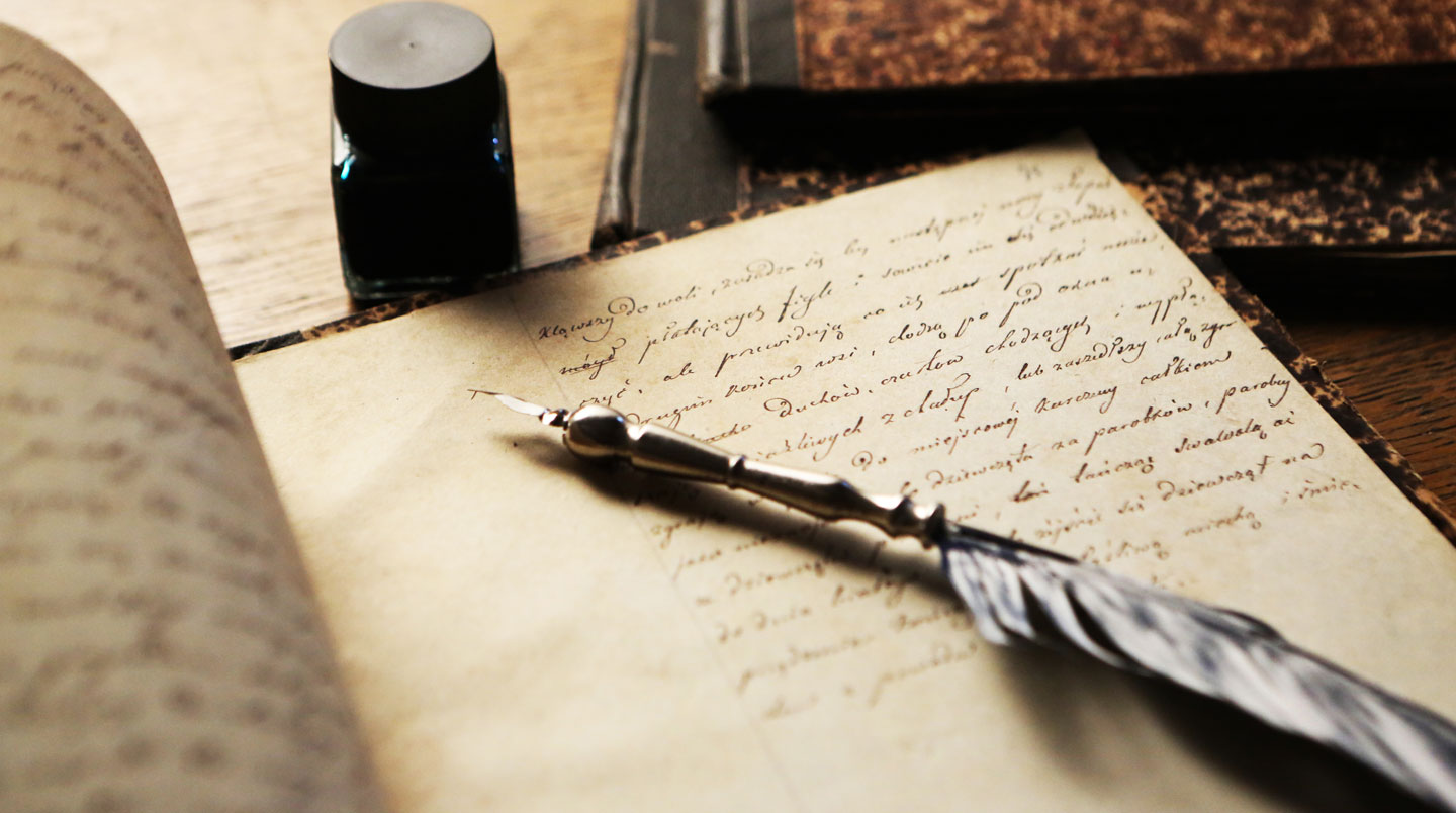 Vue de dos d'une personne penchée sur un manuscrit ancien posé sur un bureau, lumière naturelle de fenêtre